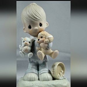 Little boy holding cat and dog figurine